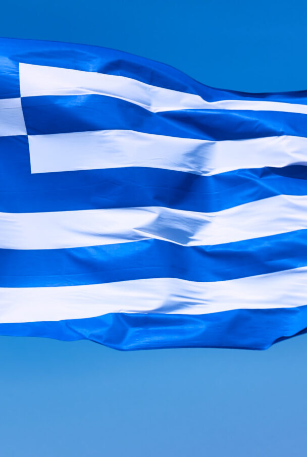 Flag of Greece close-up. Waving national greek flag agaist the blue sky